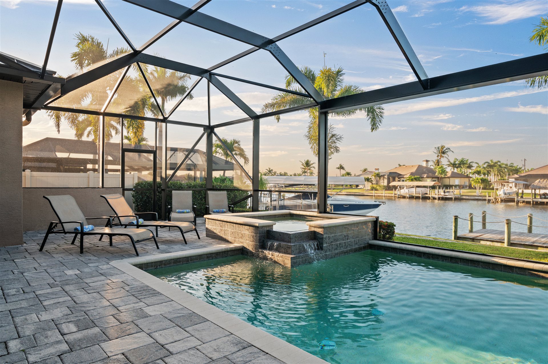 Pool and hot tub inside the screened lanai with canal view