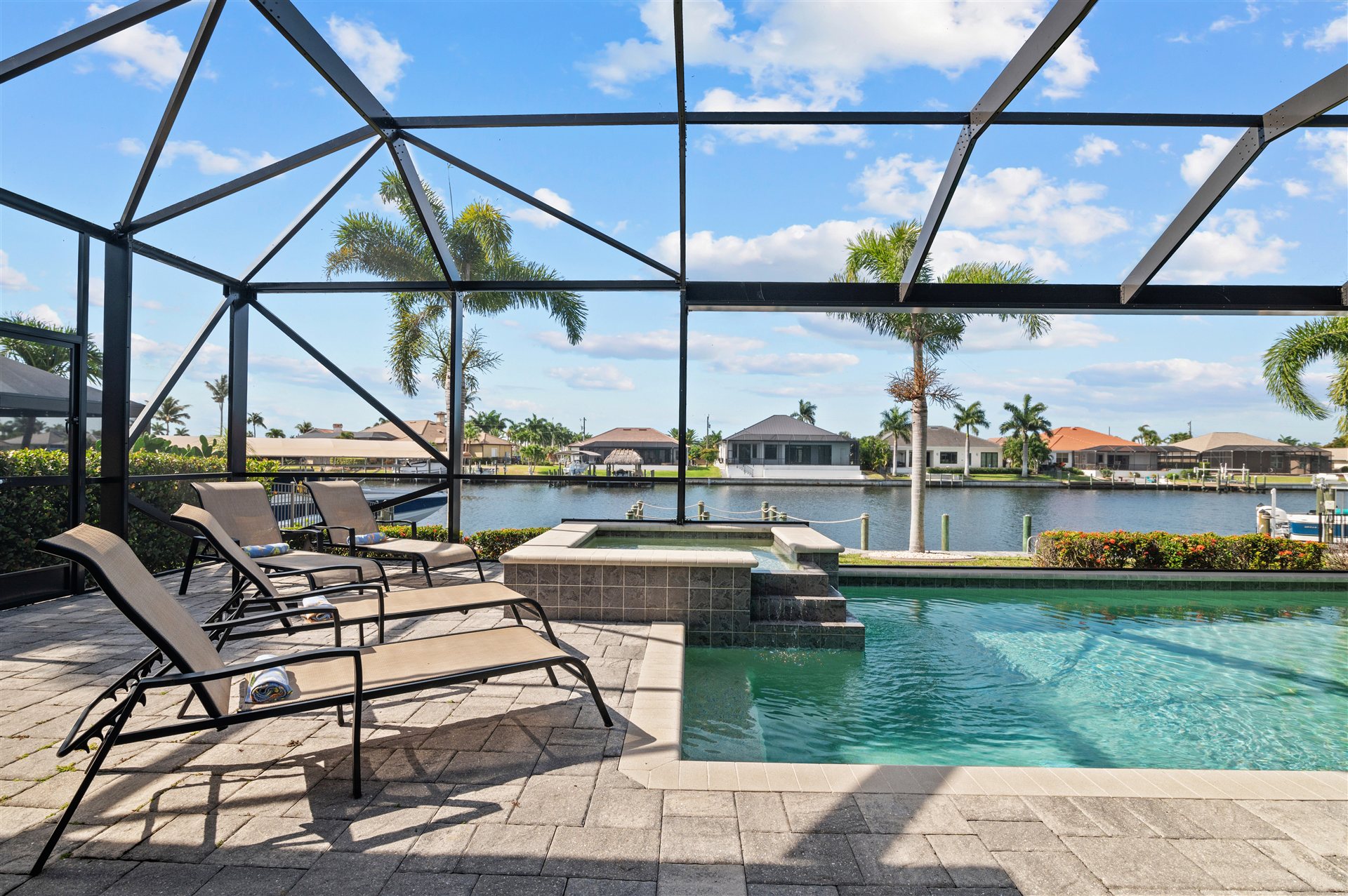 Sun loungers by the pool and hot tub in the screened lanai